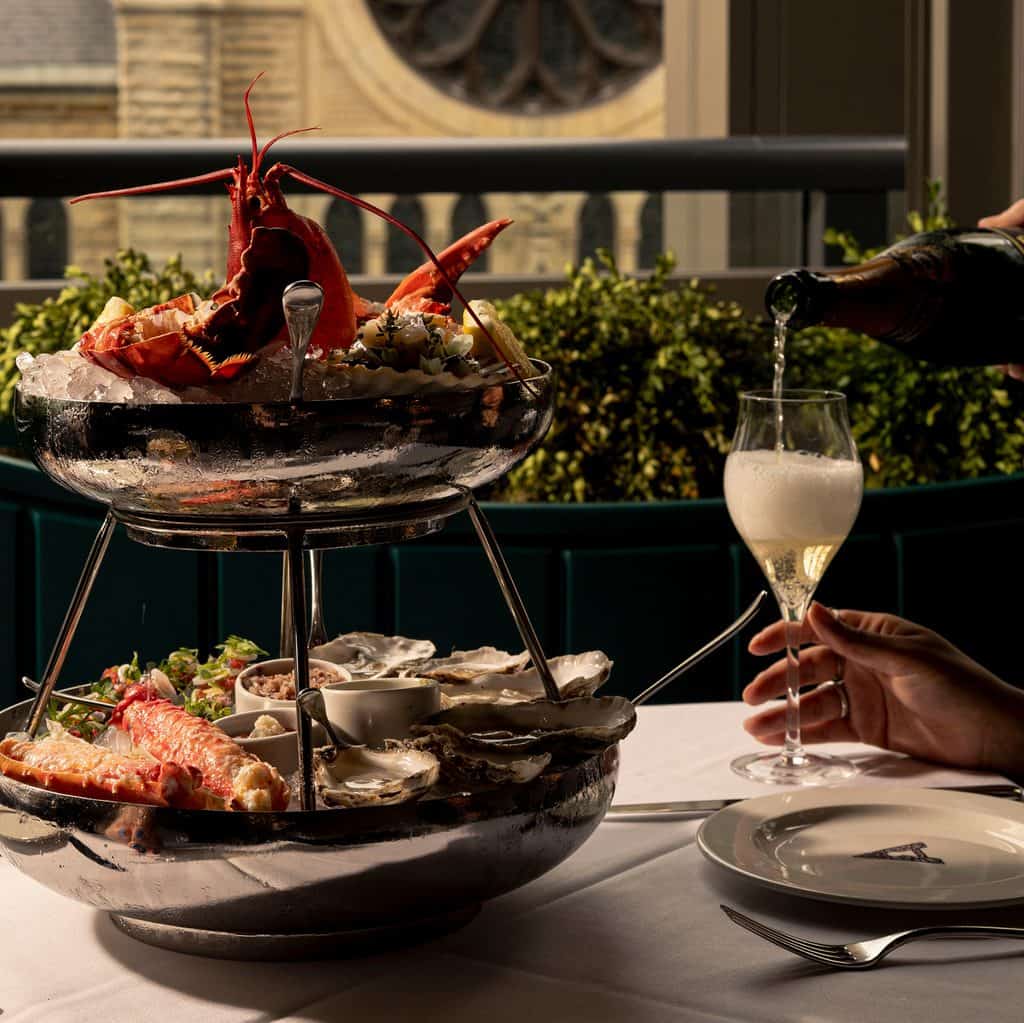 Elegant seafood tower with lobster, oysters, and champagne at The Alston.