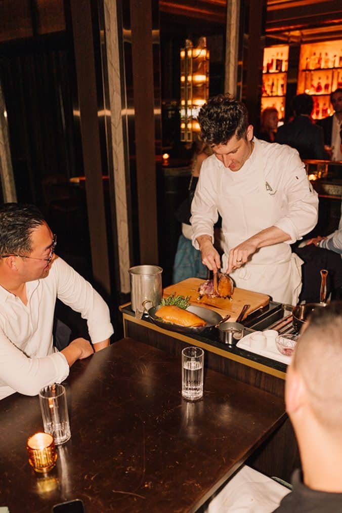Chef preparing a dish at The Alston restaurant in a stylish setting.